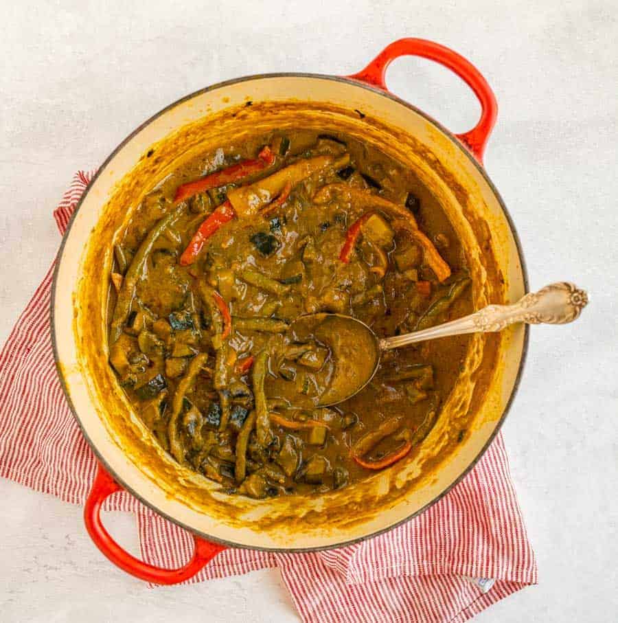 veggie curry in bowl with spoon on red striped towel