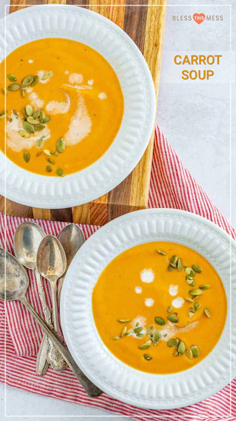 two bowls of carrot soup garnished with cream and pumpkin seeds