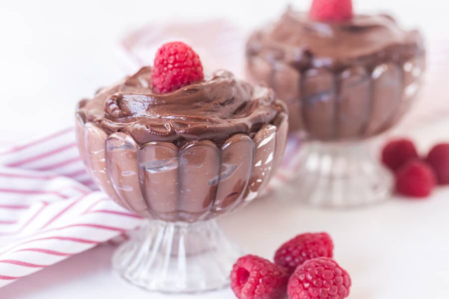 chocolate pudding in a pretty dish with raspberry on top