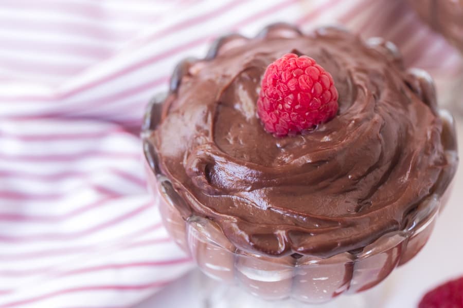 chocolate pudding in a pretty dish with raspberry on top