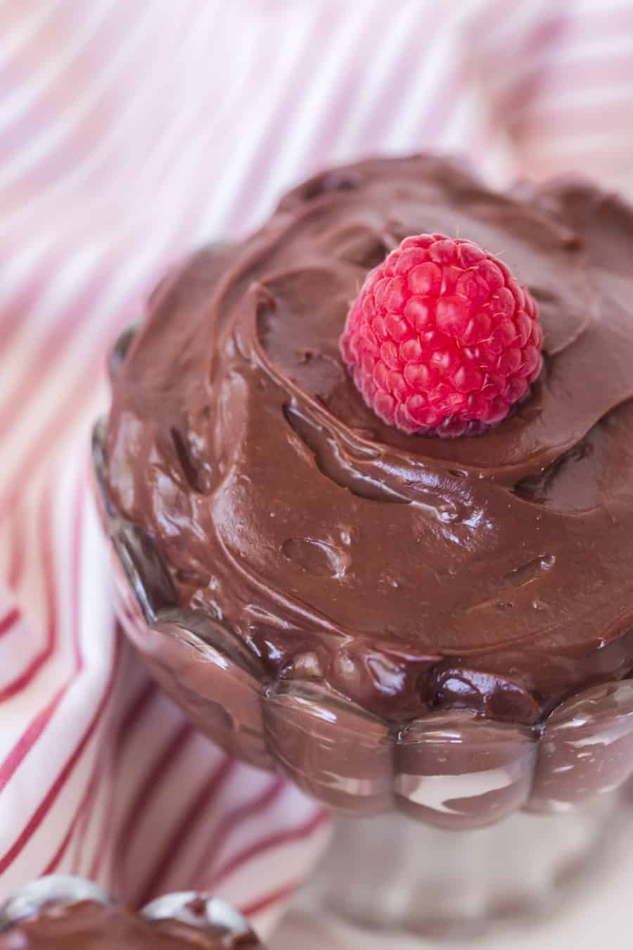 chocolate pudding in a pretty dish with raspberry on top