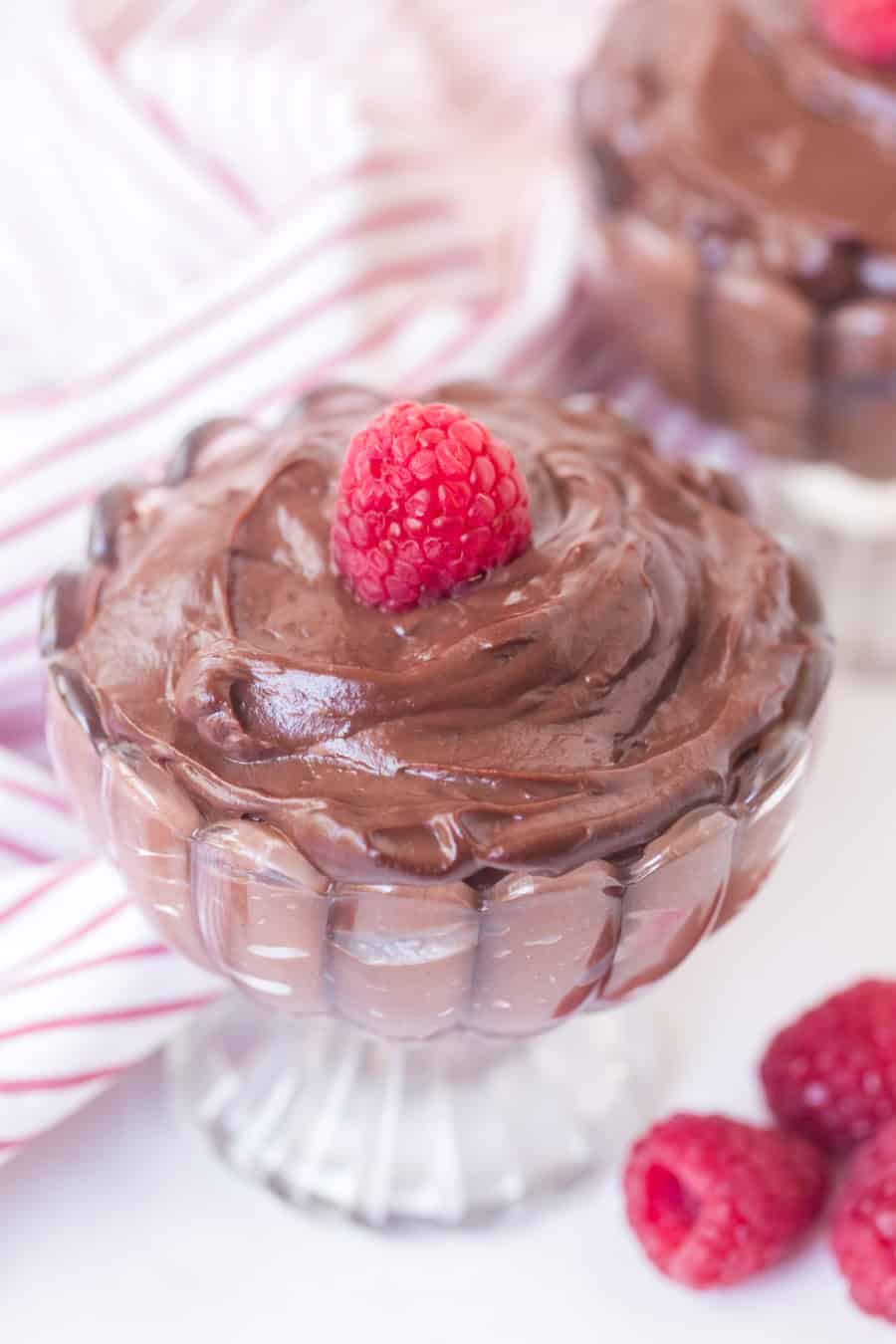 chocolate pudding in a pretty dish with raspberry on top