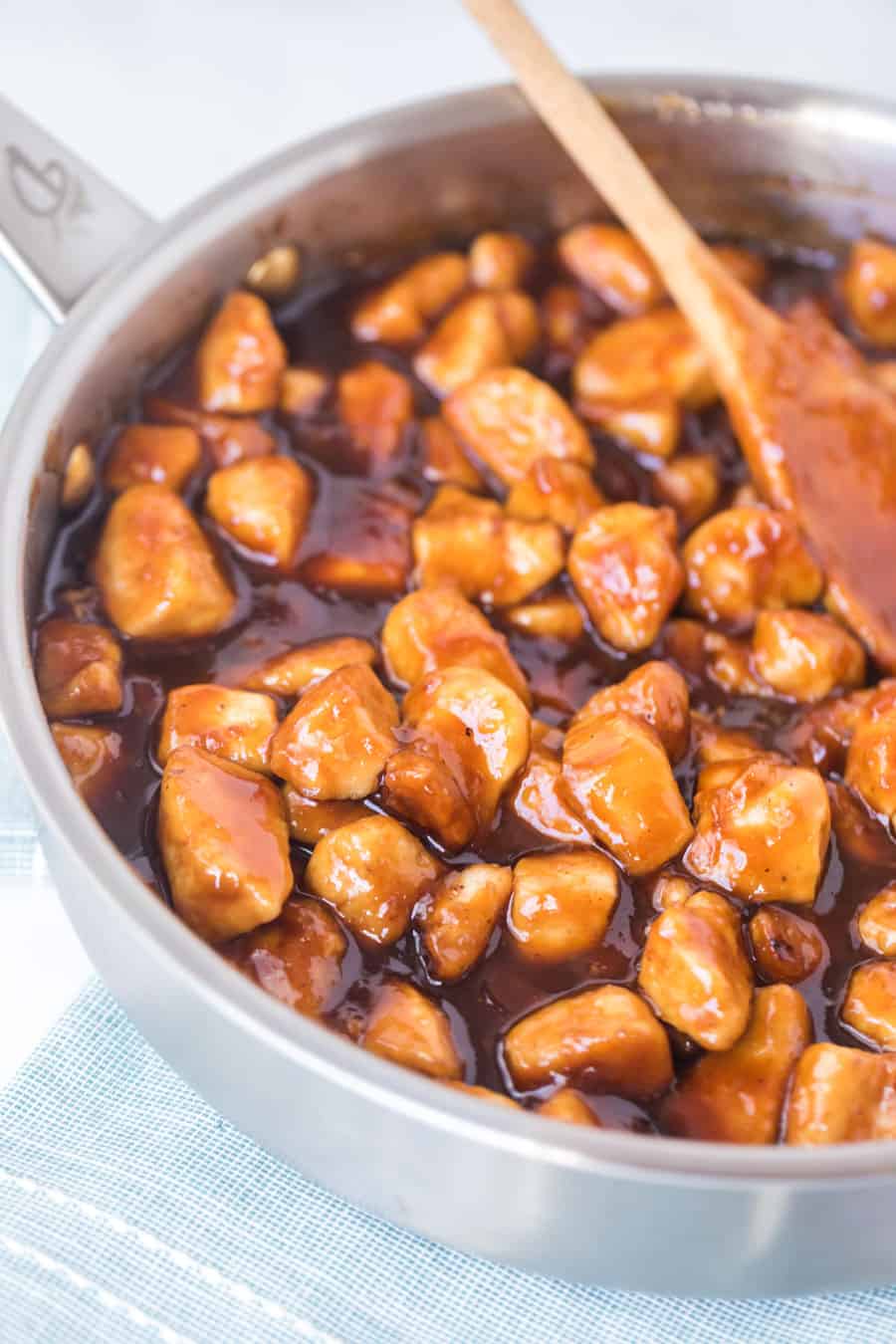 general tso's chicken in skillet with wooden spoon