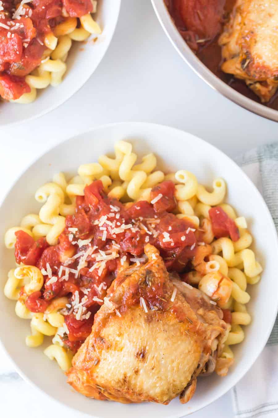 tomato and garlic cavatappi pasta with chicken thigh in white bowl