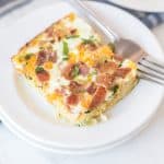 a square of egg bake like quiche without the crust on a white plate with a fork