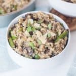 close up - mushroom and asparagus risotto in a bowl garnished with cheese shavings