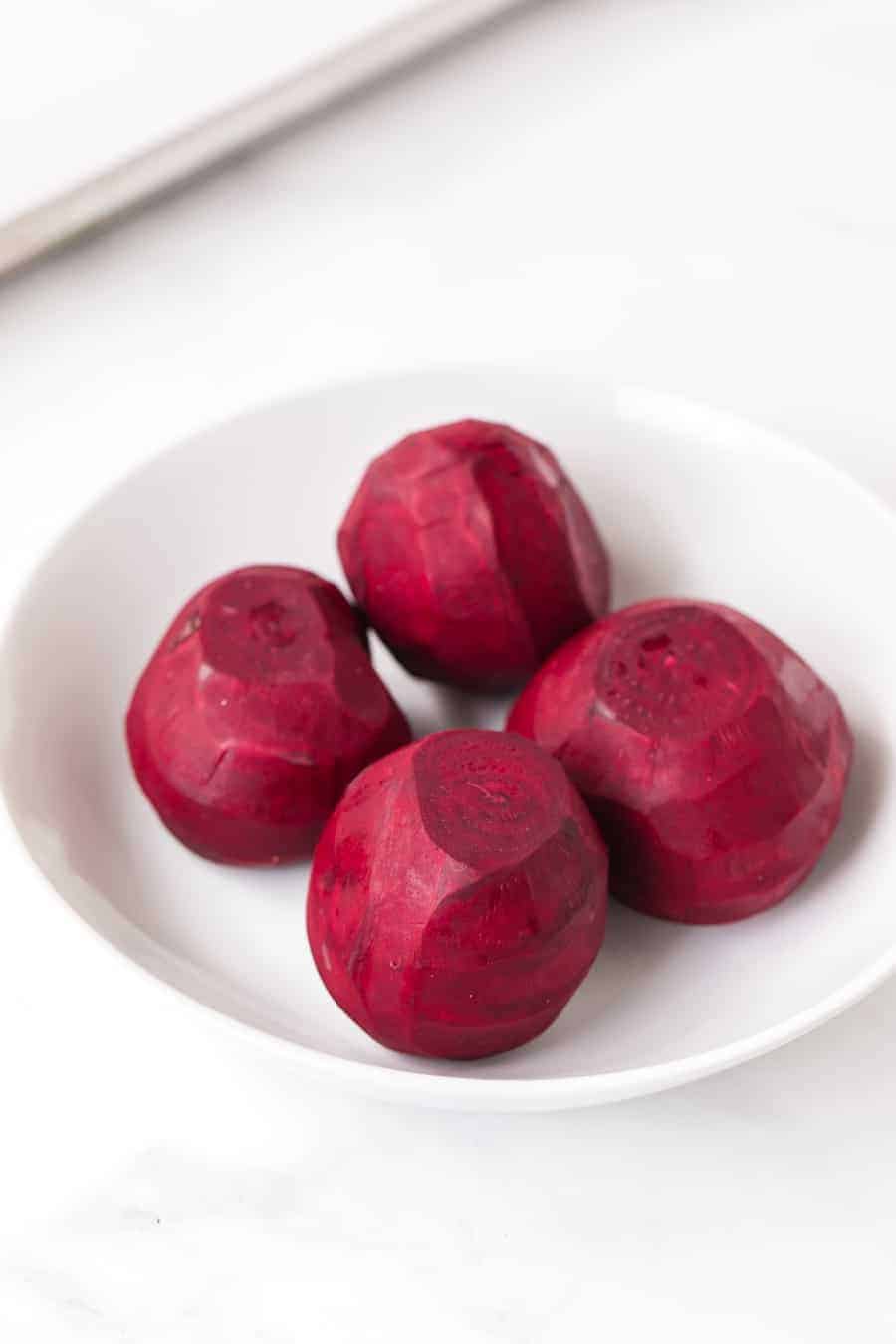 skinned uncooked beets in round white bowl