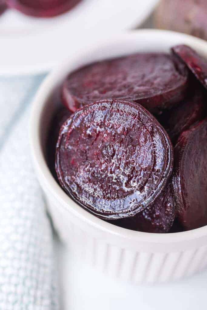 pile of roasted beet slices in a little white dish up close.