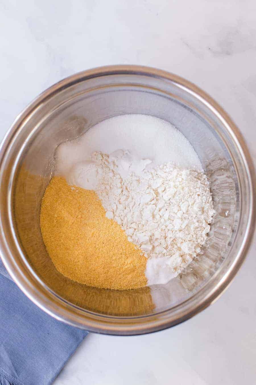 top view of ingredients for cornbread batter in a metal mixing bowl