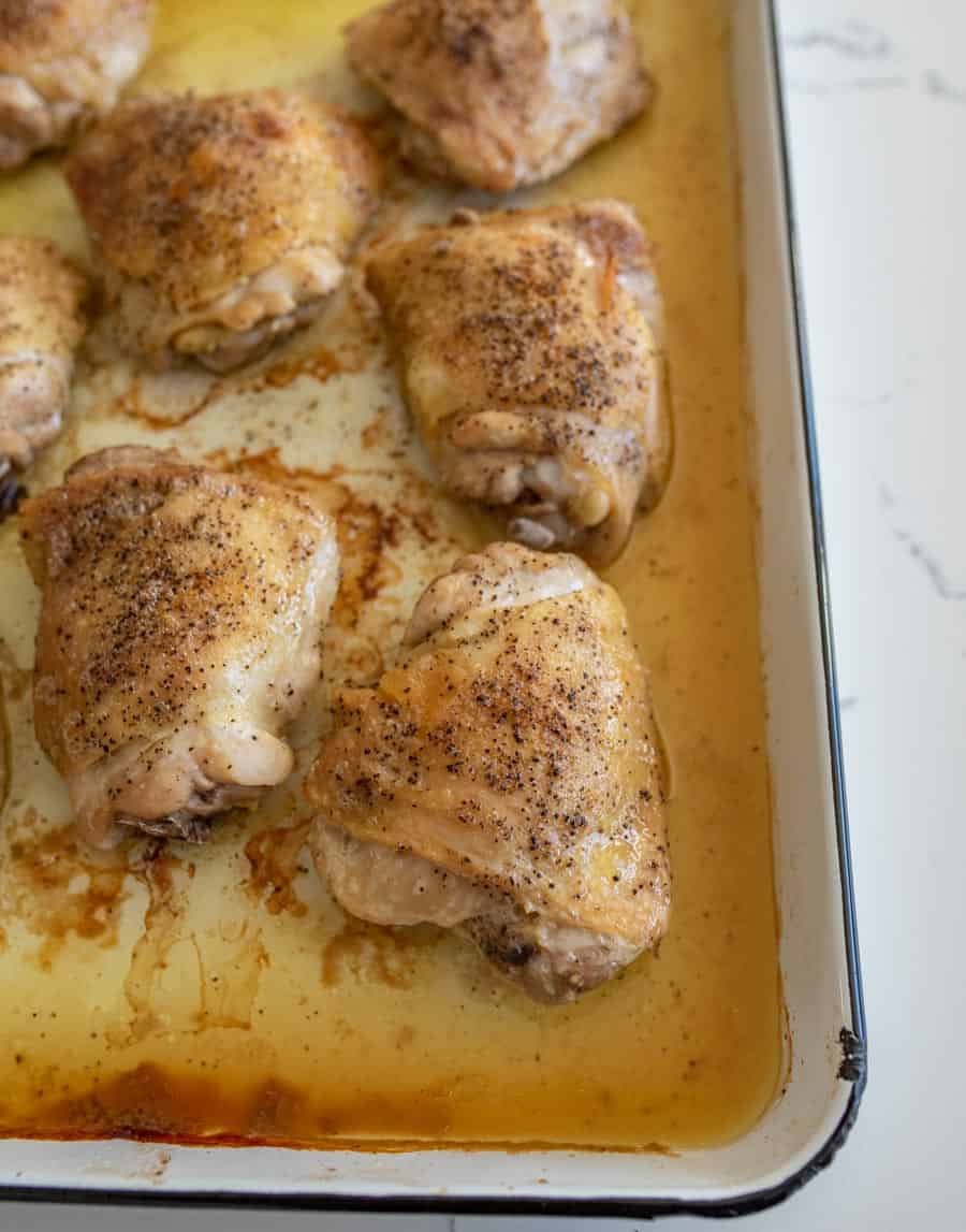 oven baked chicken thighs in juices on baking sheet