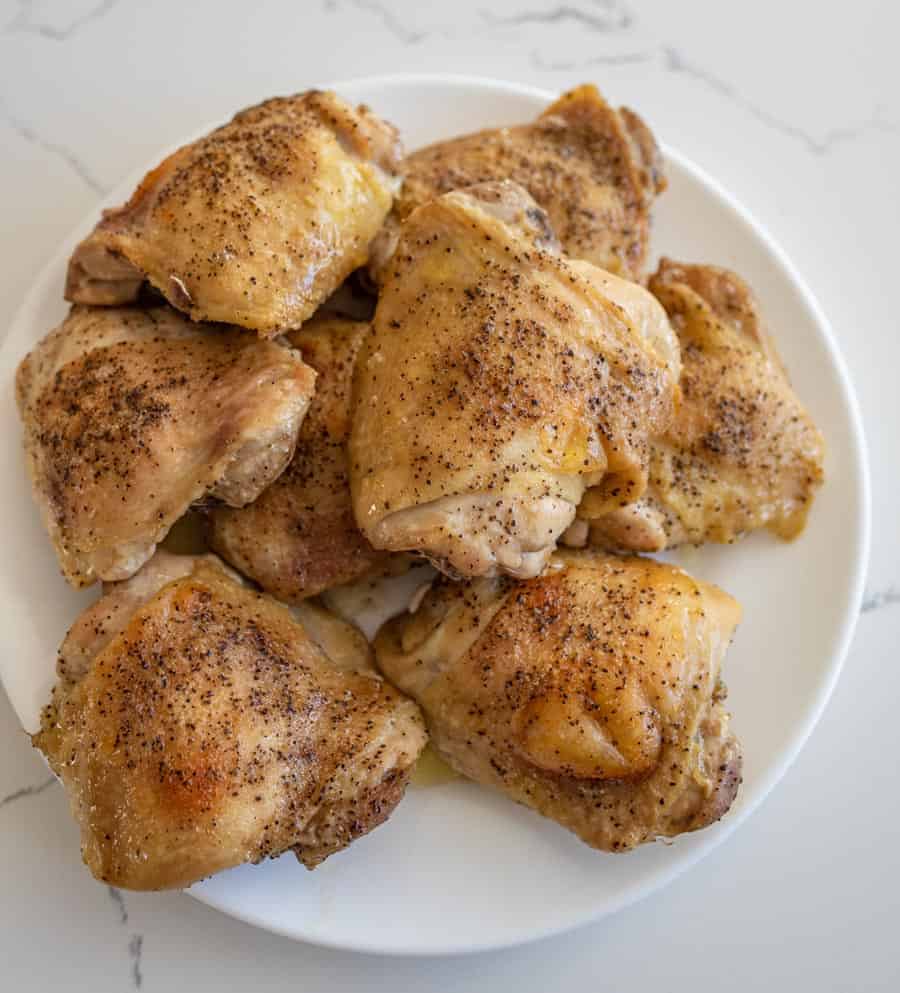 baked chicken thighs on round white plate on white countertop