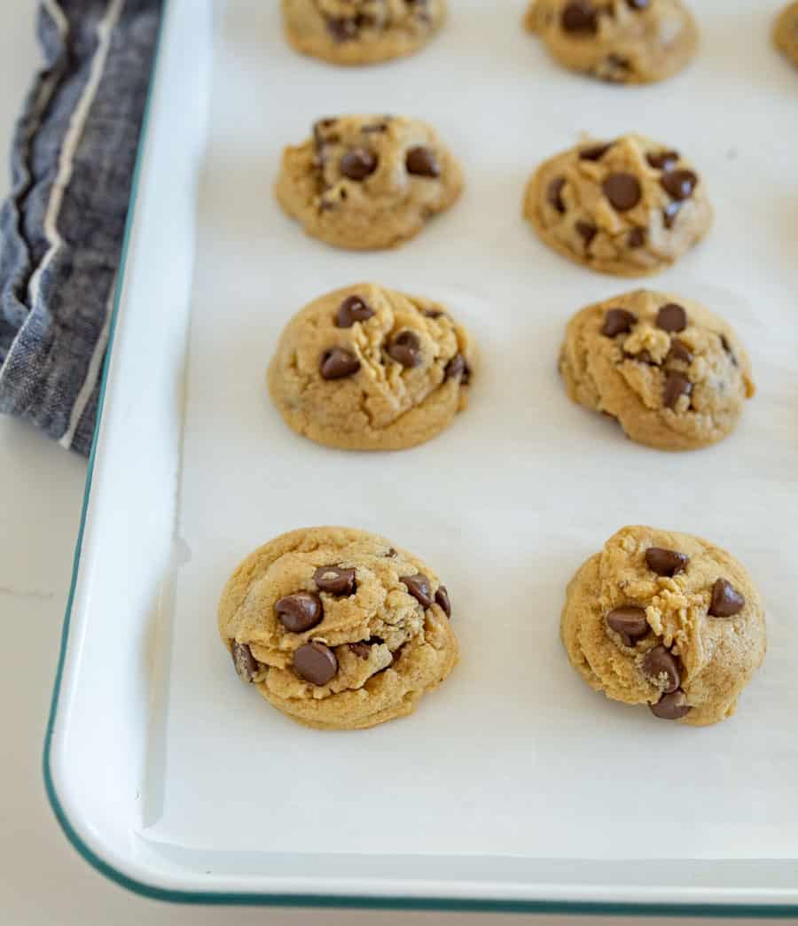 baked chocolate chip cookies on a baking sheet in rows