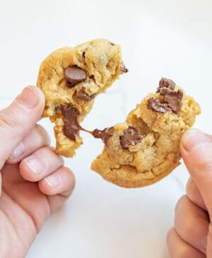 hands pulling apart a delicious chocolate chip cookie