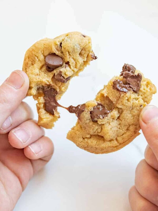 hands pulling apart a delicious chocolate chip cookie