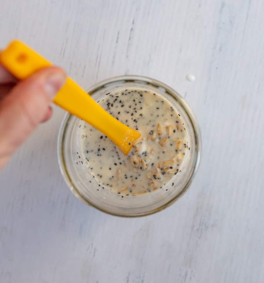 orange spoon stirring overnight oats top view