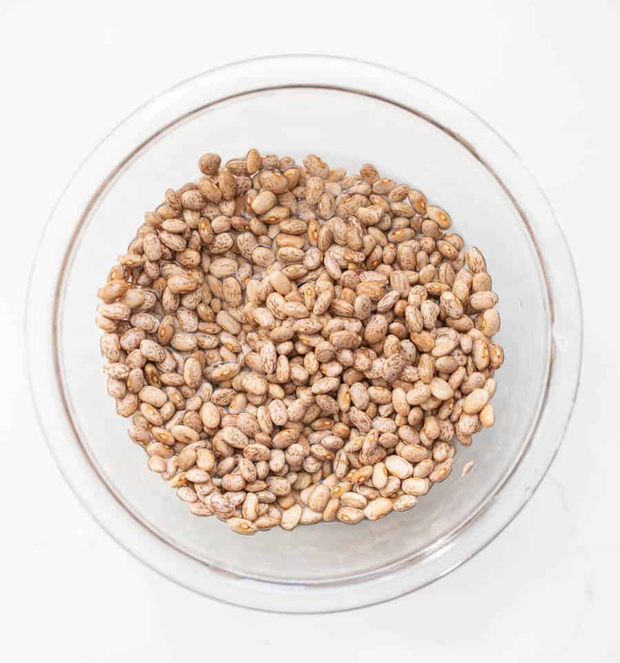 white beans in a clear glass bowl on white countertop