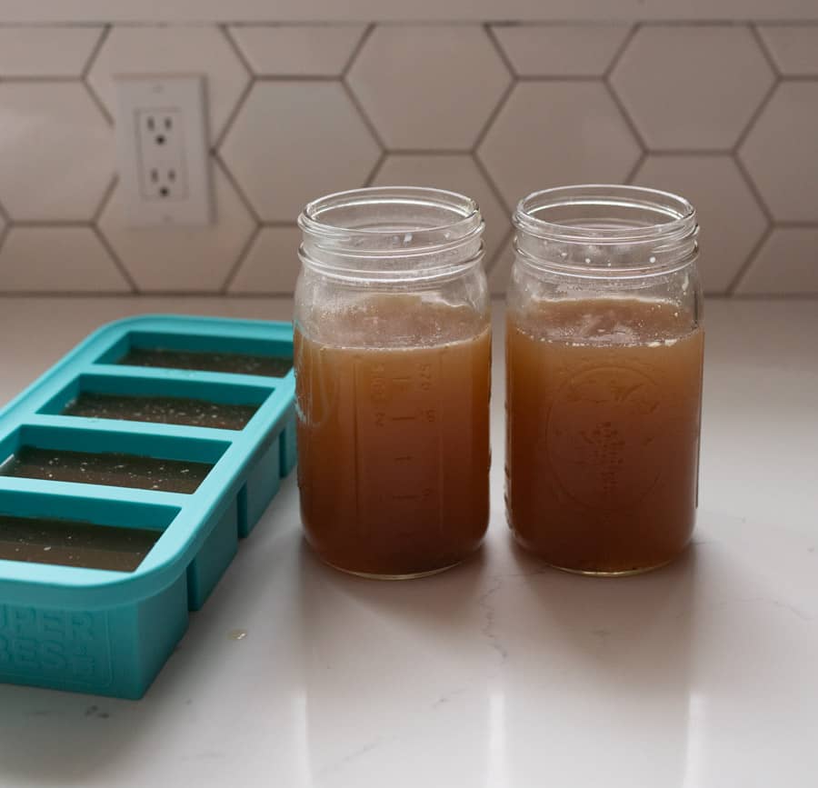 two canning jars of beef bone broth on white counter top