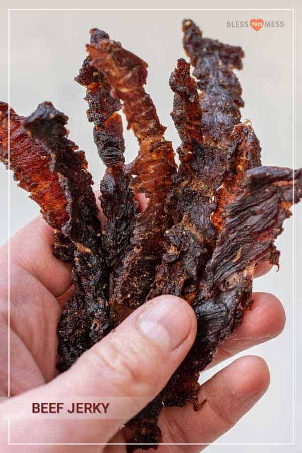 woman holding beef jerky strips