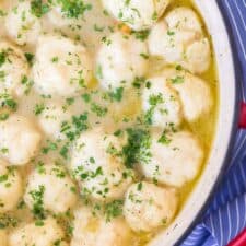 chicken and dumplings in white bowl on blue and white towel