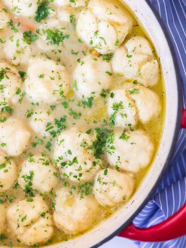 chicken and dumplings in white bowl on blue and white towel