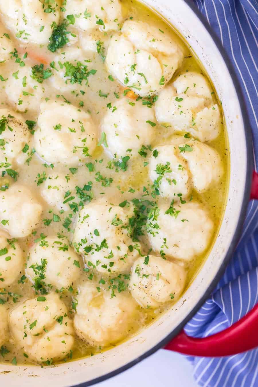 chicken and dumplings in white bowl on blue and white towel