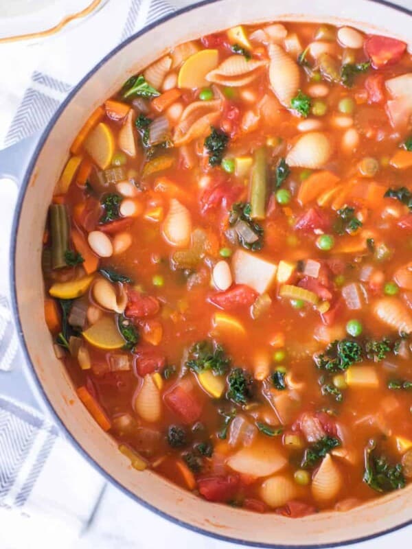 classic minestrone soup in round white bowl with blue rim