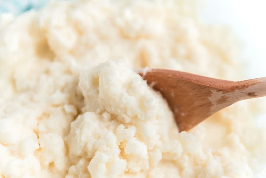 wooden spoon scooping vanilla snow ice cream