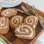 whole wheat flour carrot cake rolls with icing inside cut open on a cutting board
