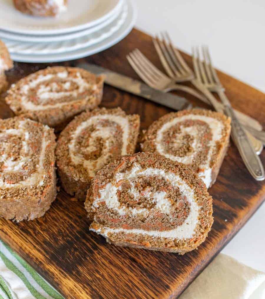 whole wheat flour carrot cake rolls with icing inside cut open on a cutting board