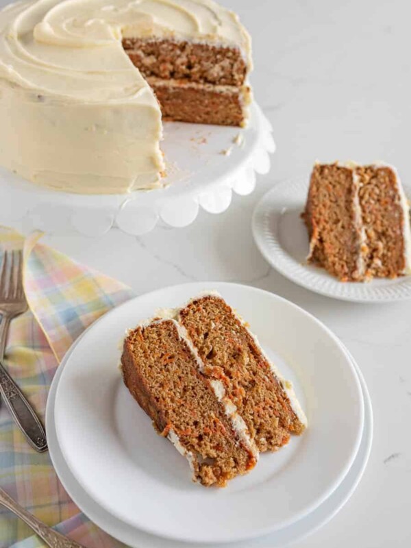 slices of carrot cake taken from the 2 tier cake in the background