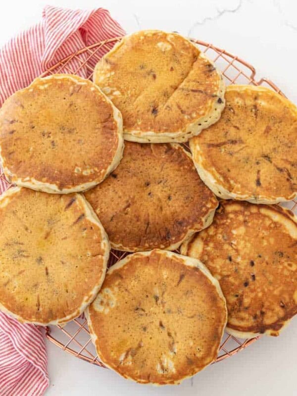 fluffy chocolate chip pancakes on cooling rack with red and white striped towel