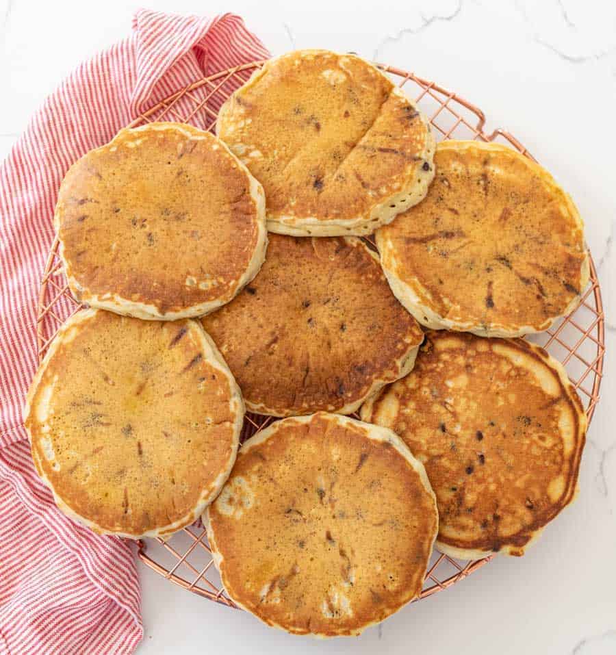 chocolate chip pancakes on wire cooling rack with red and white striped towel