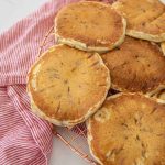 closeup of fluffy chocolate chip pancakes on cooling rack with red and white striped towel