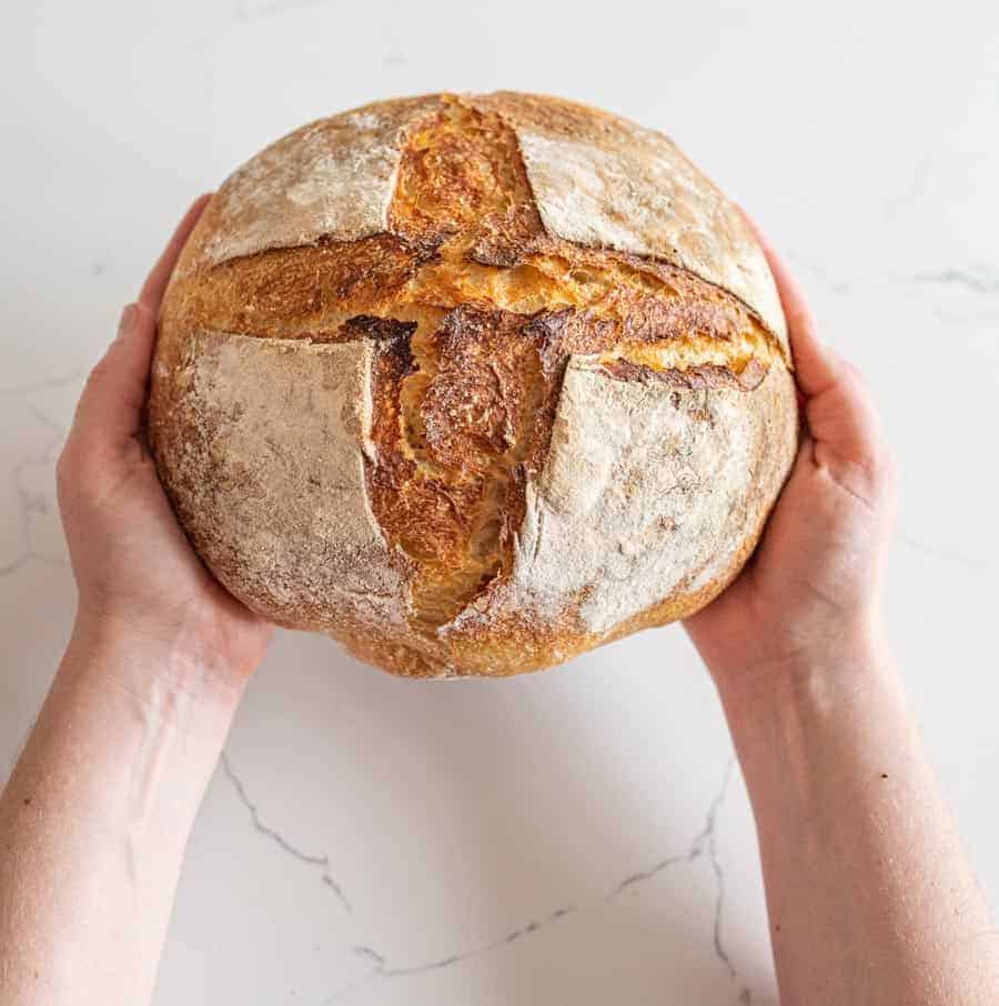 woman holding sourdough bread loaf