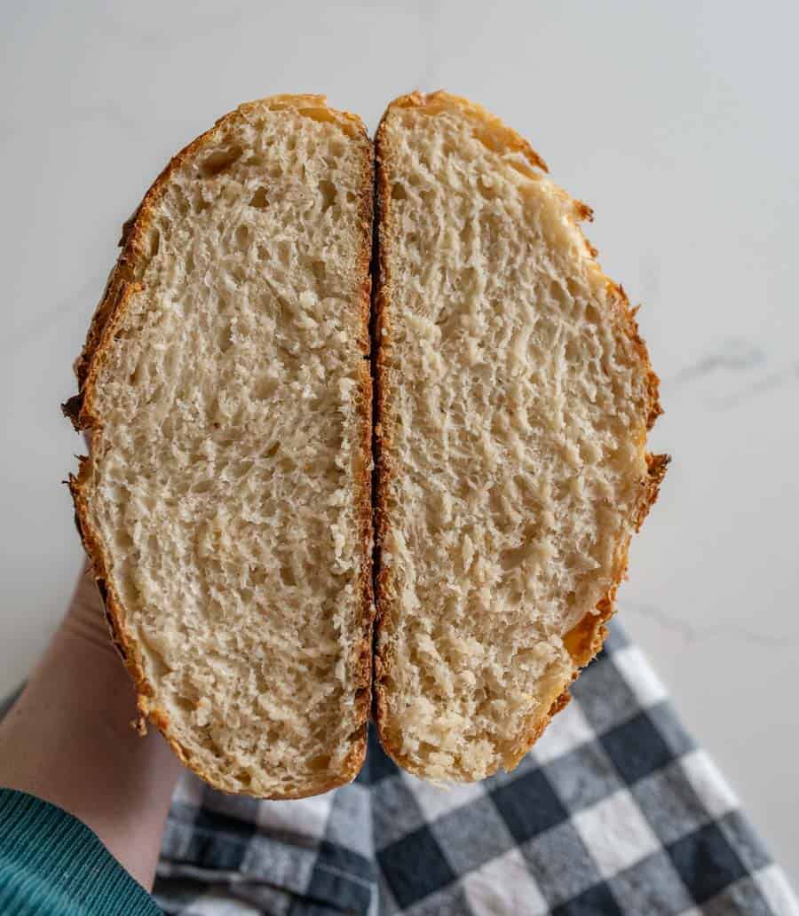 woman holding two slices of sourdough bread over black and white checkered towel