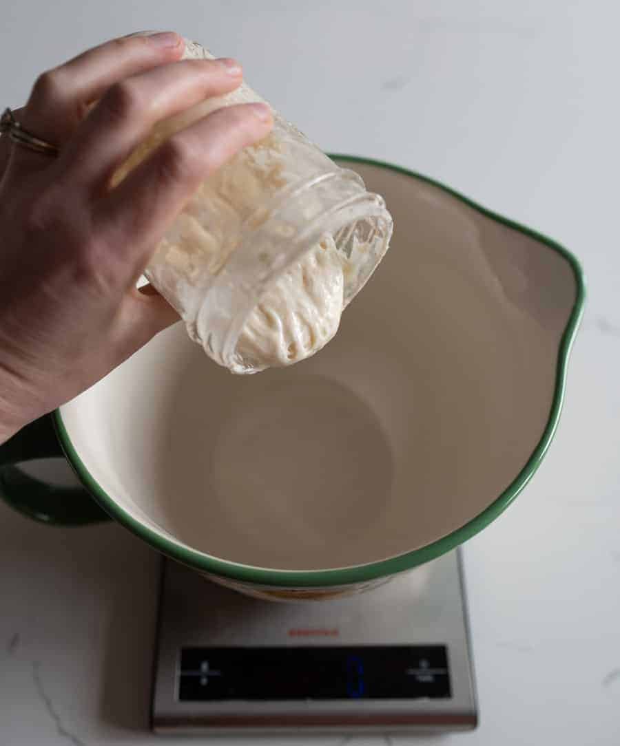 woman pouring sourdough into bowl