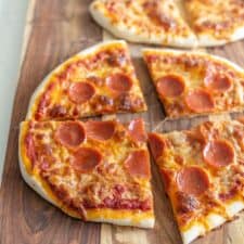 sourdough pizza with pepperoni on cutting board