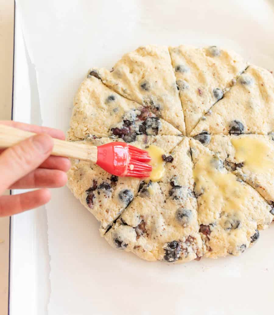 brushing butter on blueberry scones