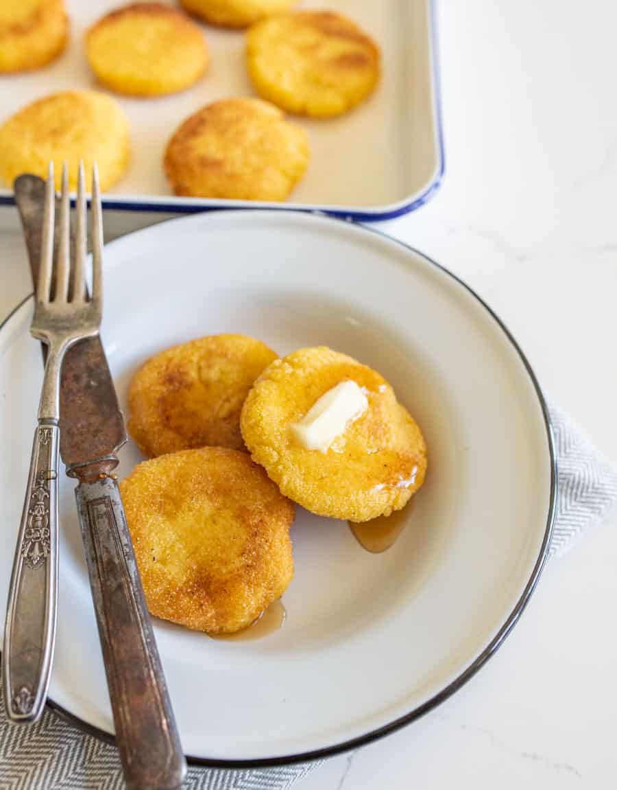 hot water cornbread with butter on white plate with knife and fork