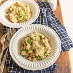 instant pot chicken and rice in white bowls on blue and white towel on cutting board with silverware