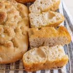 baked sourdough focaccia bread baked and sliced on cooling rack