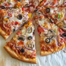 closeup of homemade veggie pizza on parchment