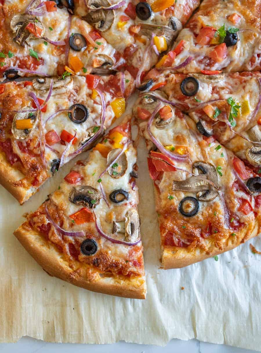 closeup of homemade veggie pizza on parchment