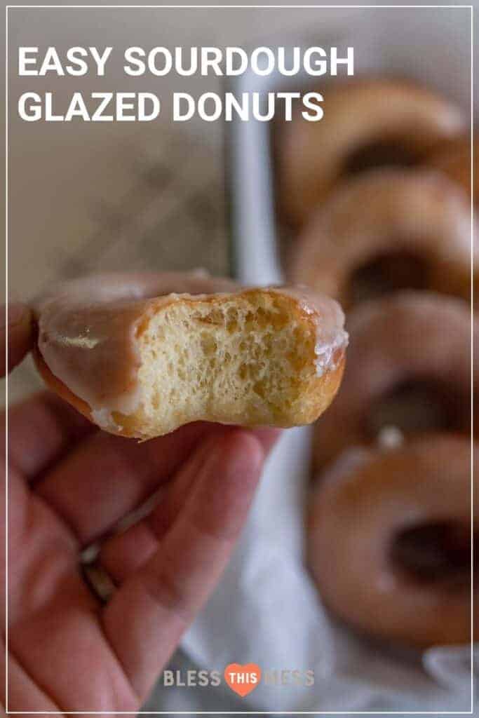 woman holding sourdough glazed donut with bite missing