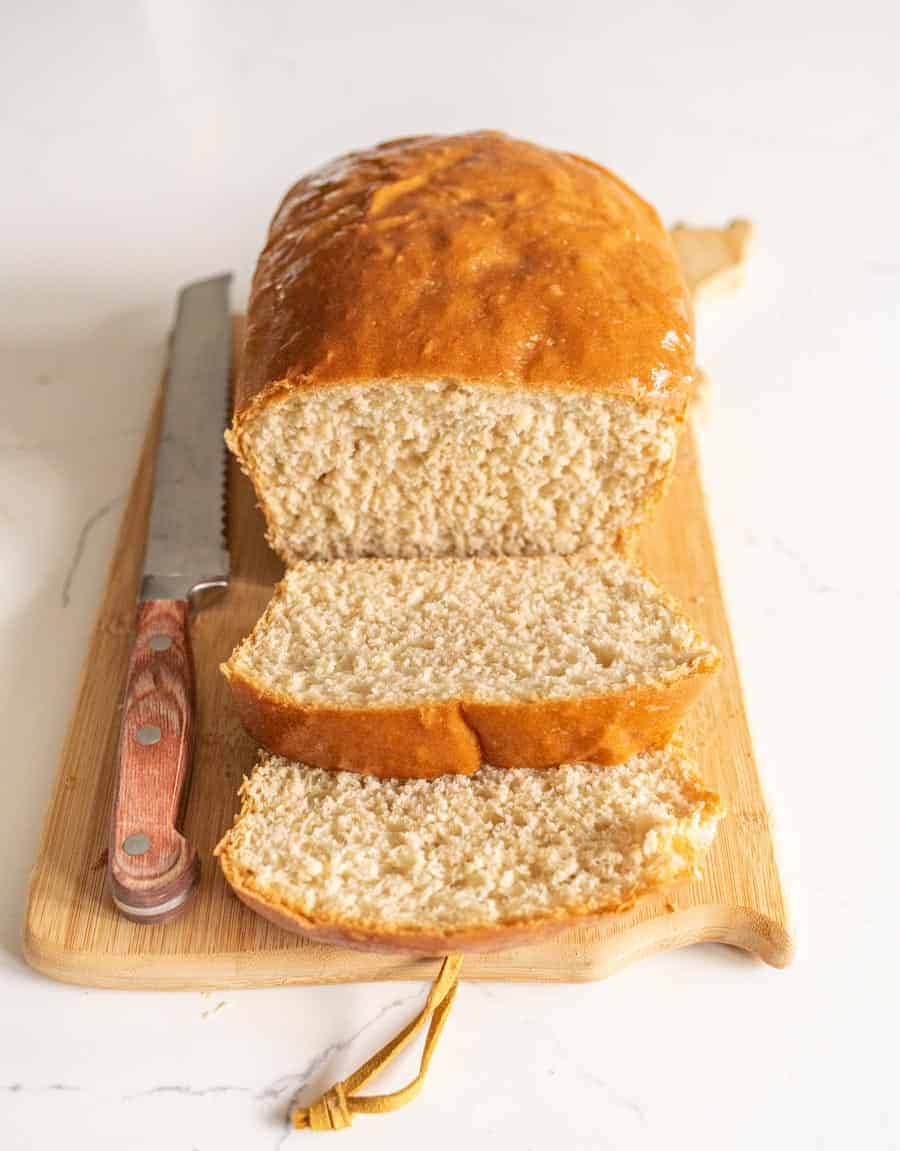 loaf of sliced bread on cutting board with knife