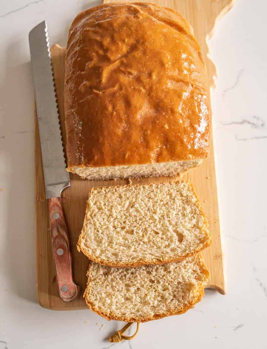 loaf of bread with knife on cutting board