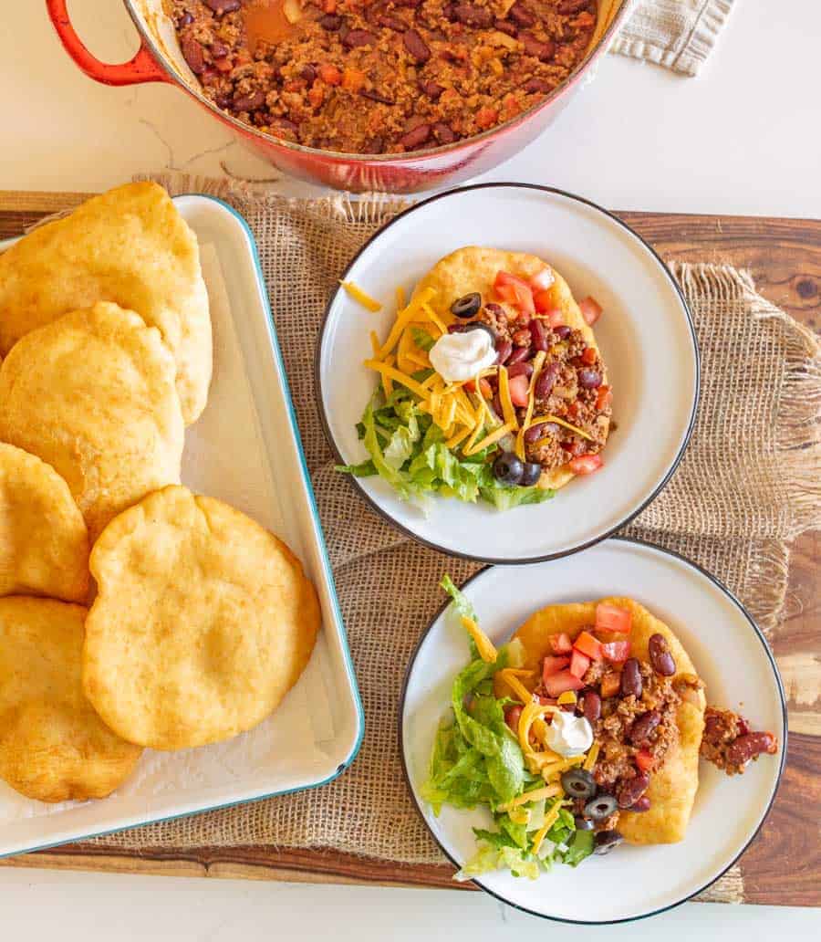 fry bread on plates made into Navajo tacos with lots of toppings