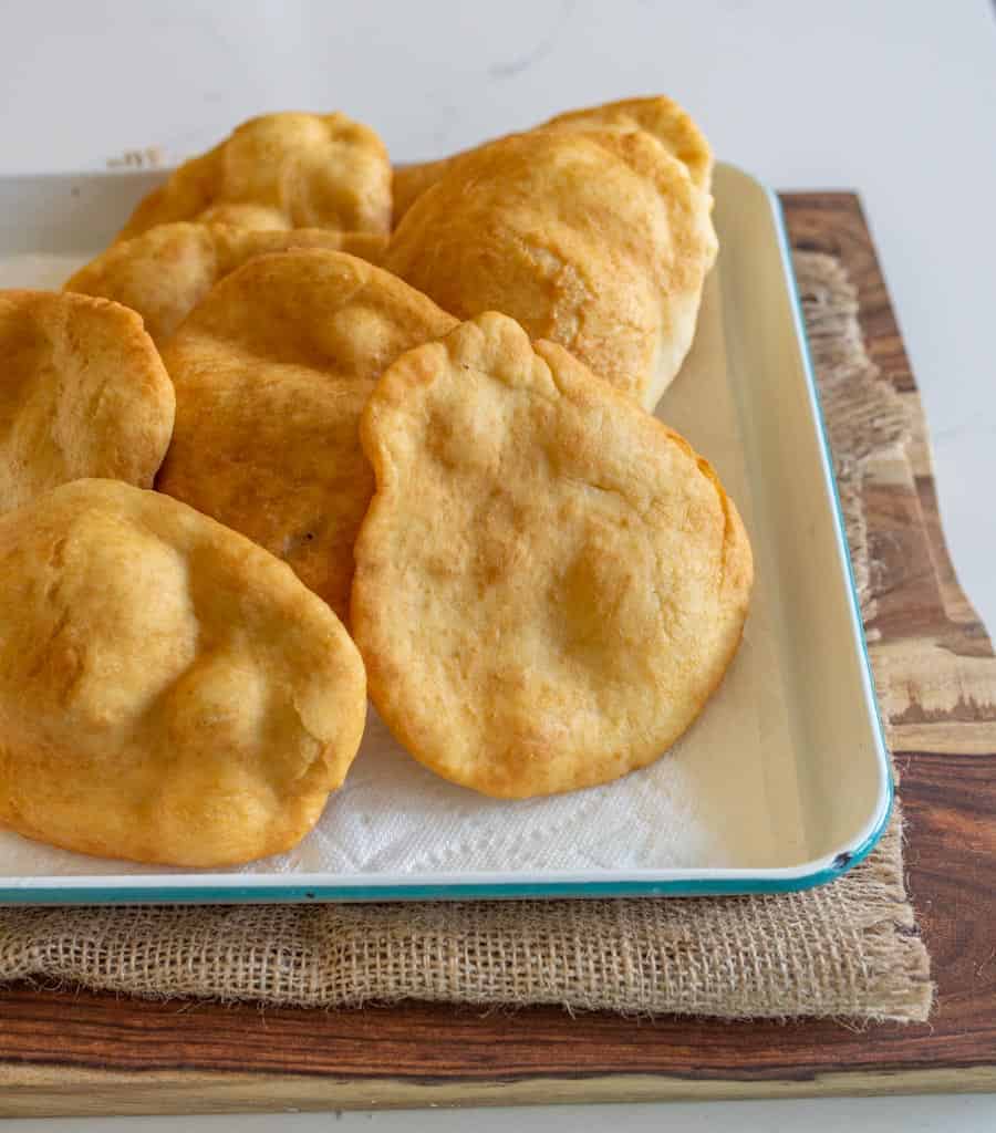 cooked fry bread on a rimmed sheet cooling