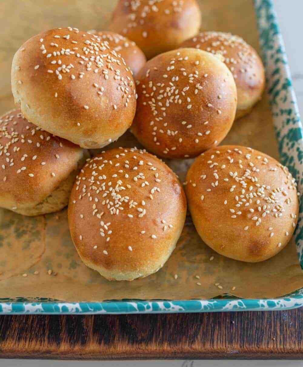 sourdough burger buns on a sheet after baking