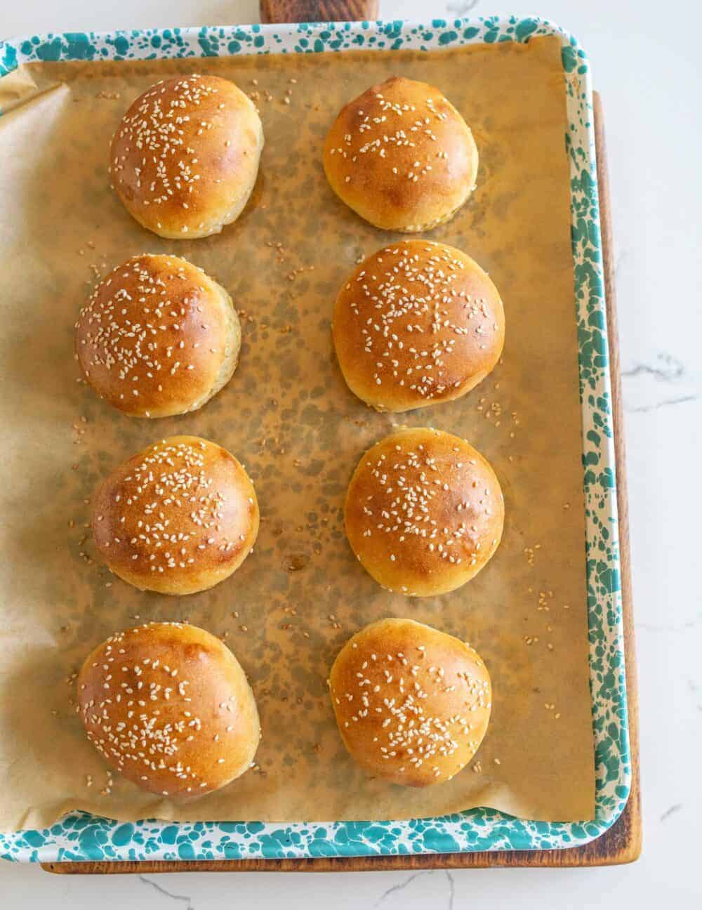 sourdough burger buns on parchment paper after baking